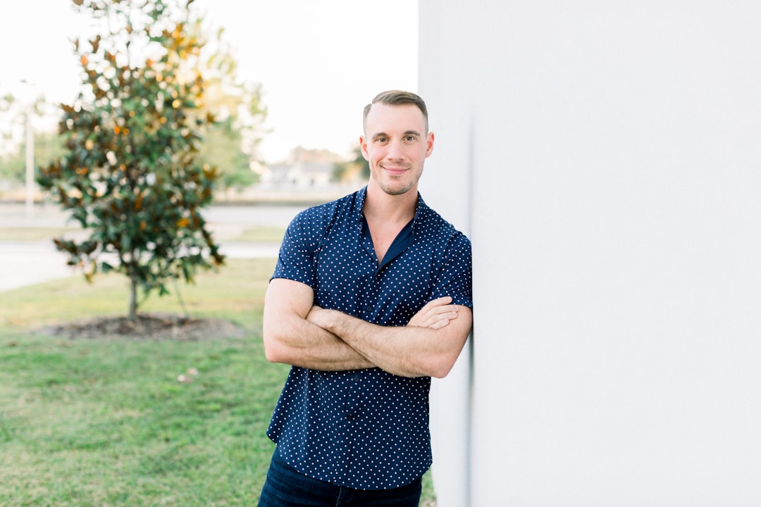 a man leaning against a wall with his arms crossed